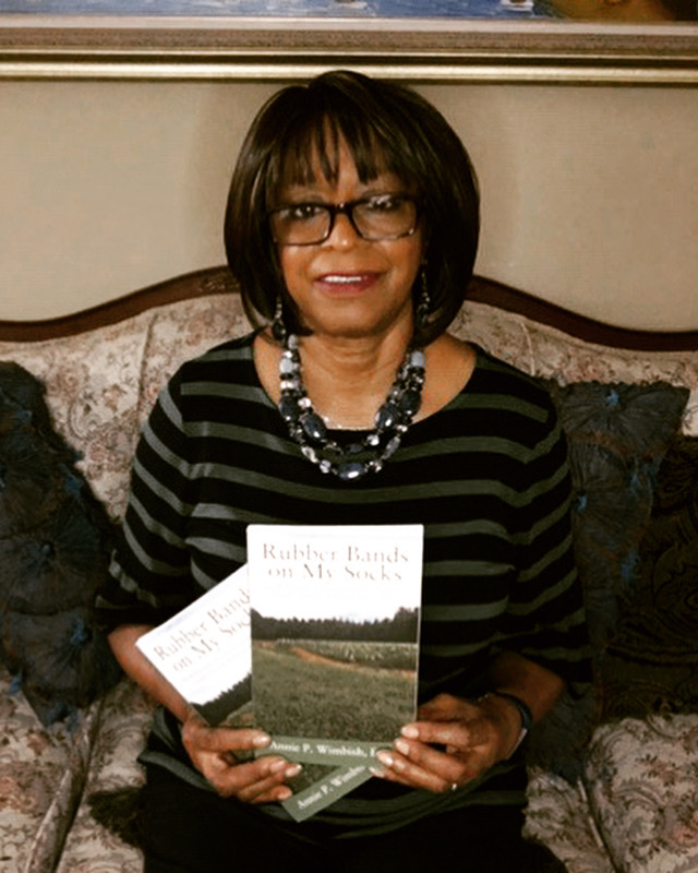 Dr. Annie 
Wimbish holds two copies of her autobiography, Rubber Bands on My Socks.