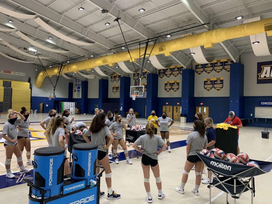 Volleyball+team+in+a+group+huddle+during+practice.+